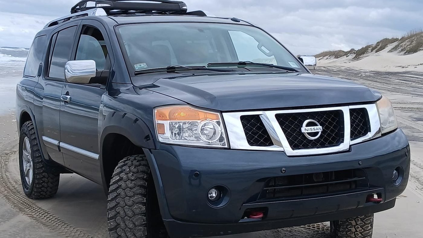Real photo: one of Beach 4x4's Nissan Armadas on the 4x4 beach with dunes behind it.